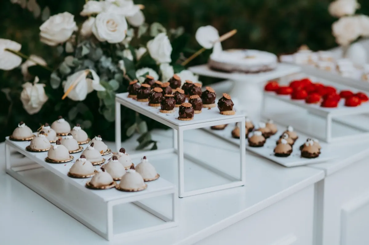 Buffet dei dolci con alzate bianche e pasticceria mignon