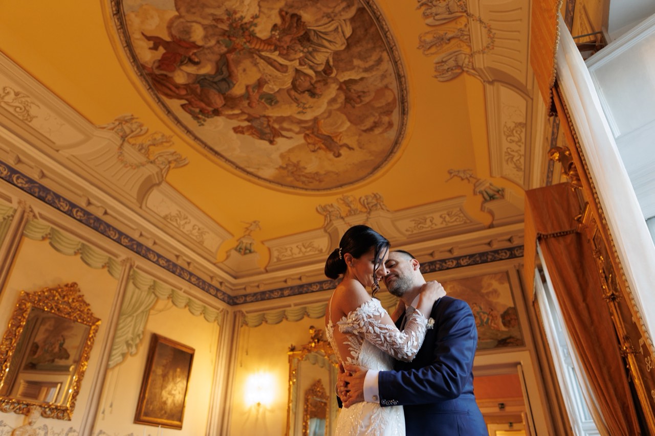 Sposi abbracciati sotto la volta affrescata di un salone di Villa Soglia