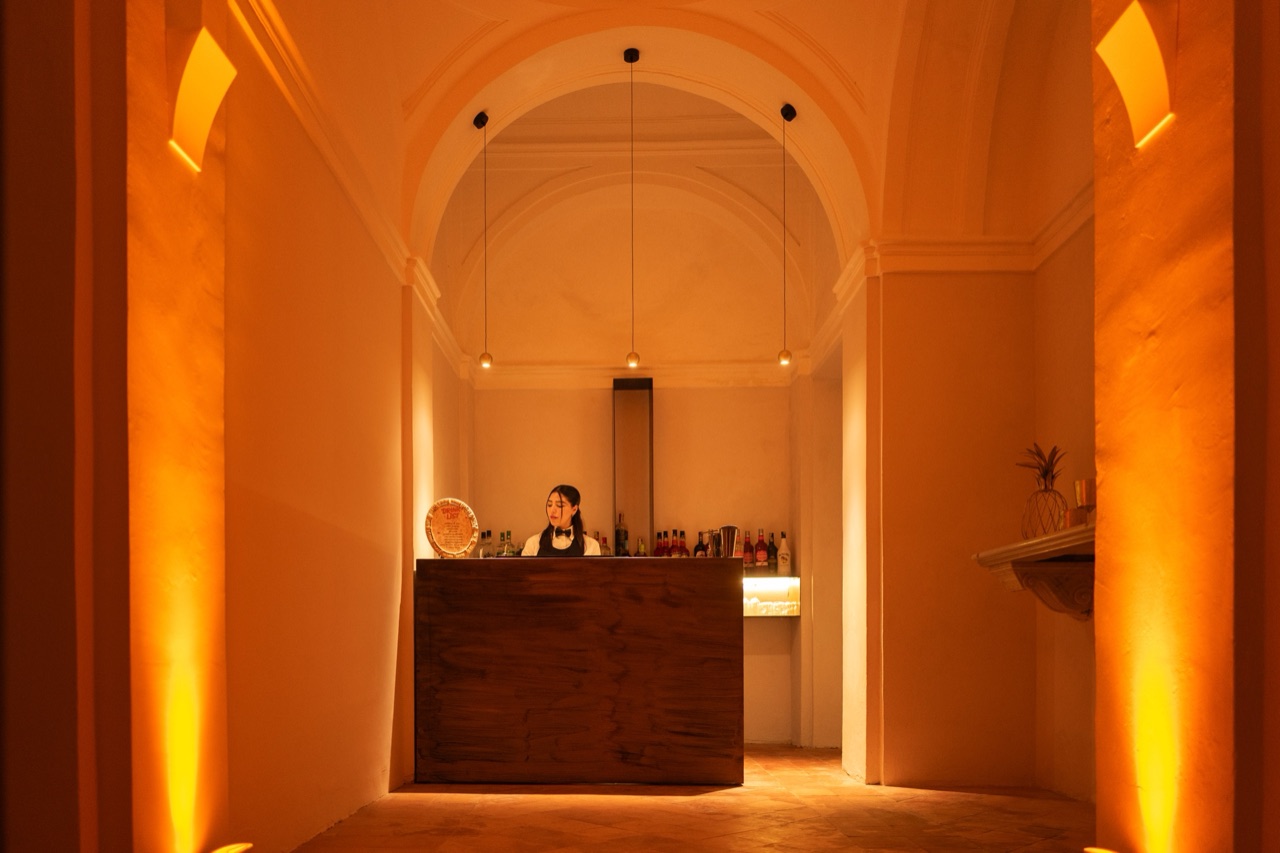 Loggia voltata allestita a cocktail bar con luce ambra