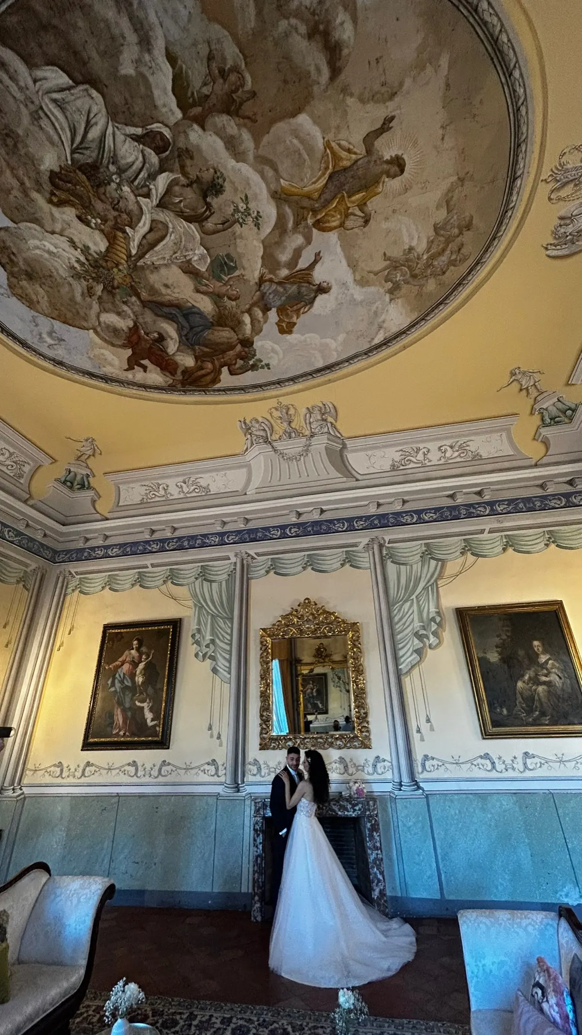 Sposi nel salone affrescato, sotto la volta dipinta e fra le cornici di stucco