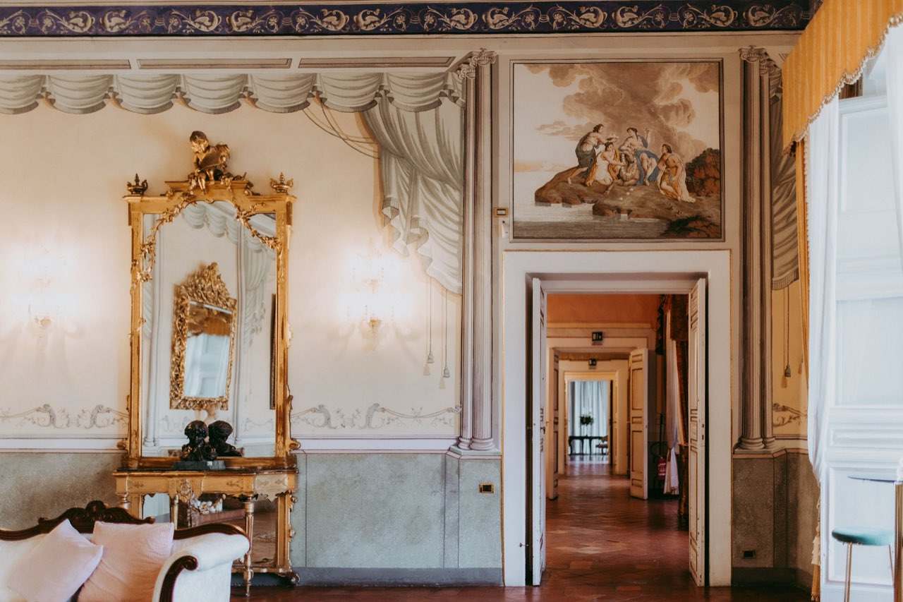 Enfilade dei saloni storici con soffitti affrescati e drappeggi dipinti a trompe-l'oeil