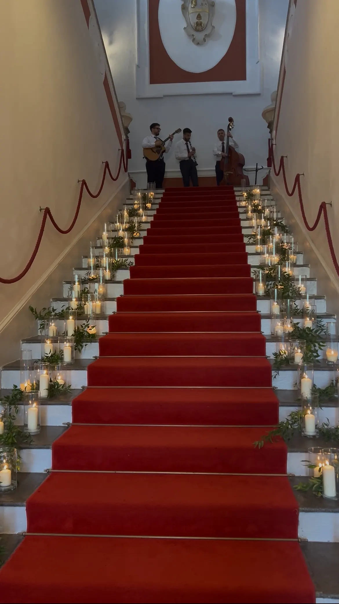 Scalone d'onore con candele su ogni gradino e musicisti in cima alla scala